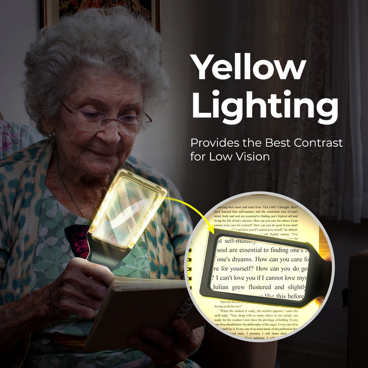 Woman using a magnifying lamp to read a book with text about yellow lighting and low vision.