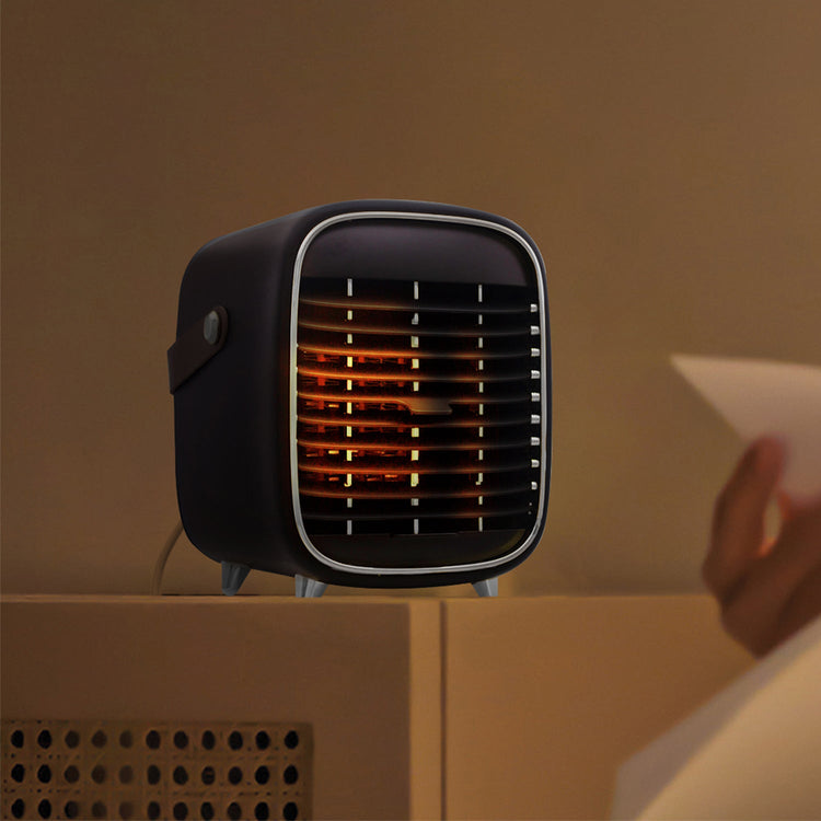 Small black heater on a beige surface with a warm glow