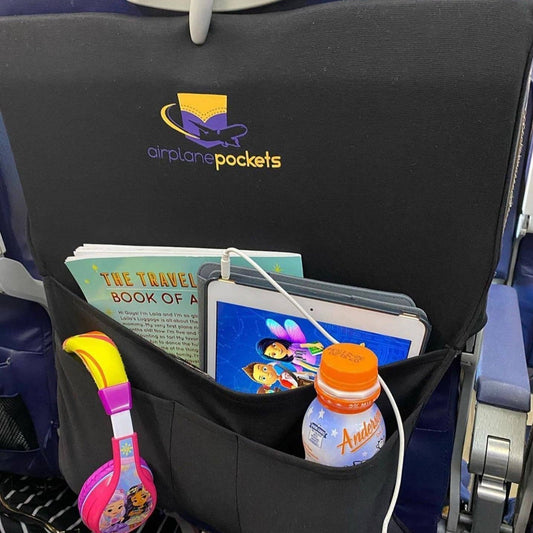 Airplane seat with 'airplane pockets' organizer holding a tablet, book, and drink.
