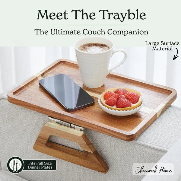 Wooden tray with cup, phone, and fruit on a couch, labeled 'Trayble' by Shamrock Home.