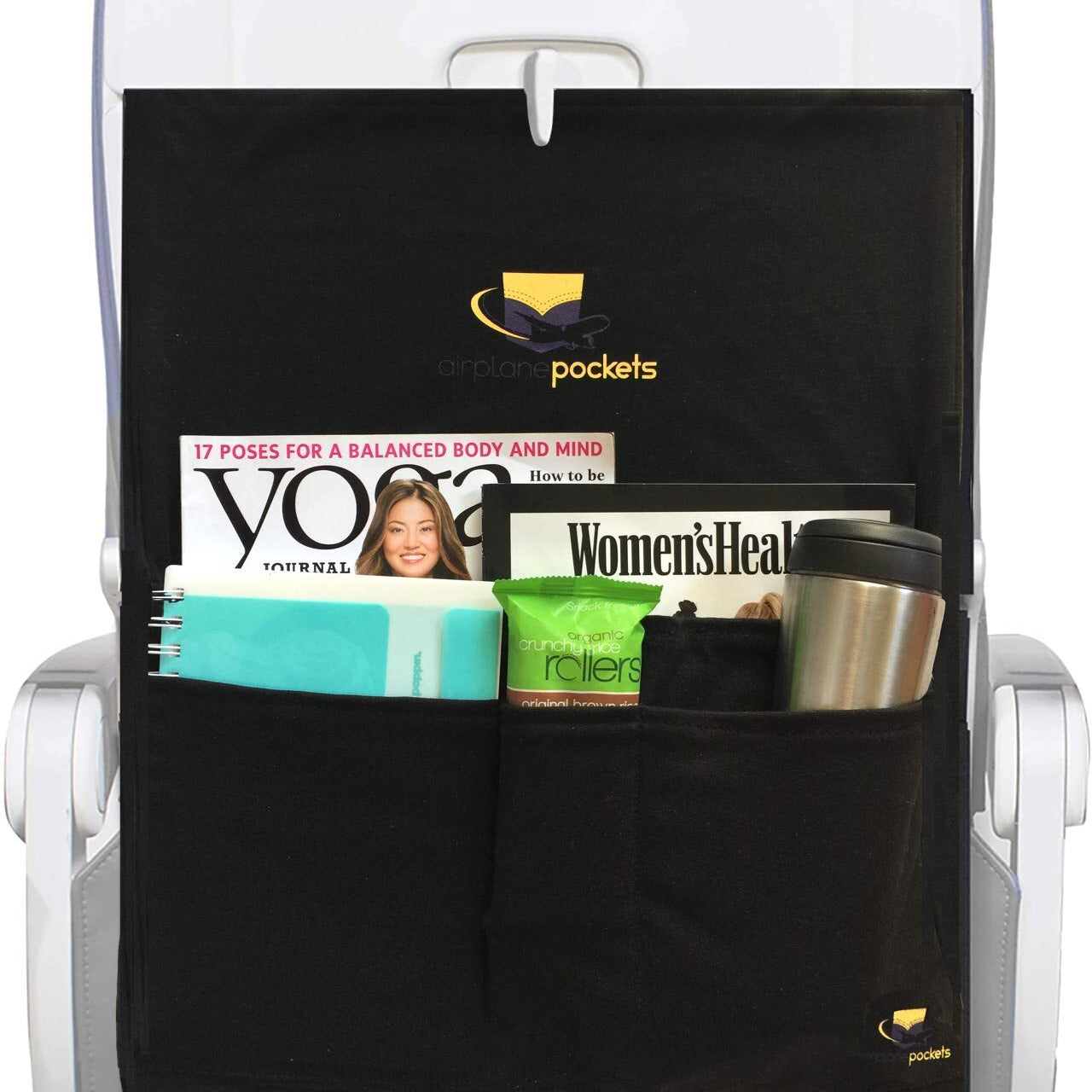 Black airplane pocket organizer attached to an airplane seat with magazines and a tumbler inside.
