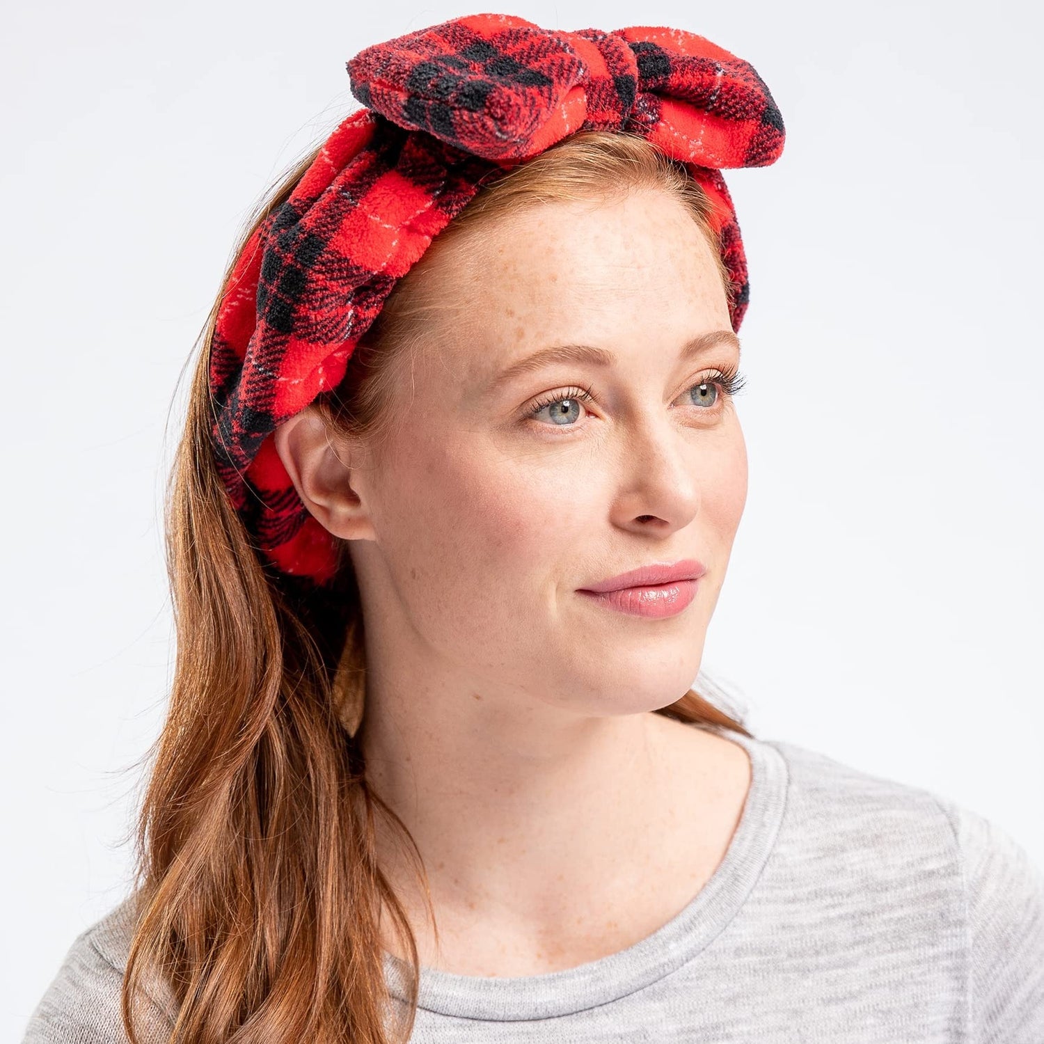 Woman wearing a red and black plaid headband on a white background