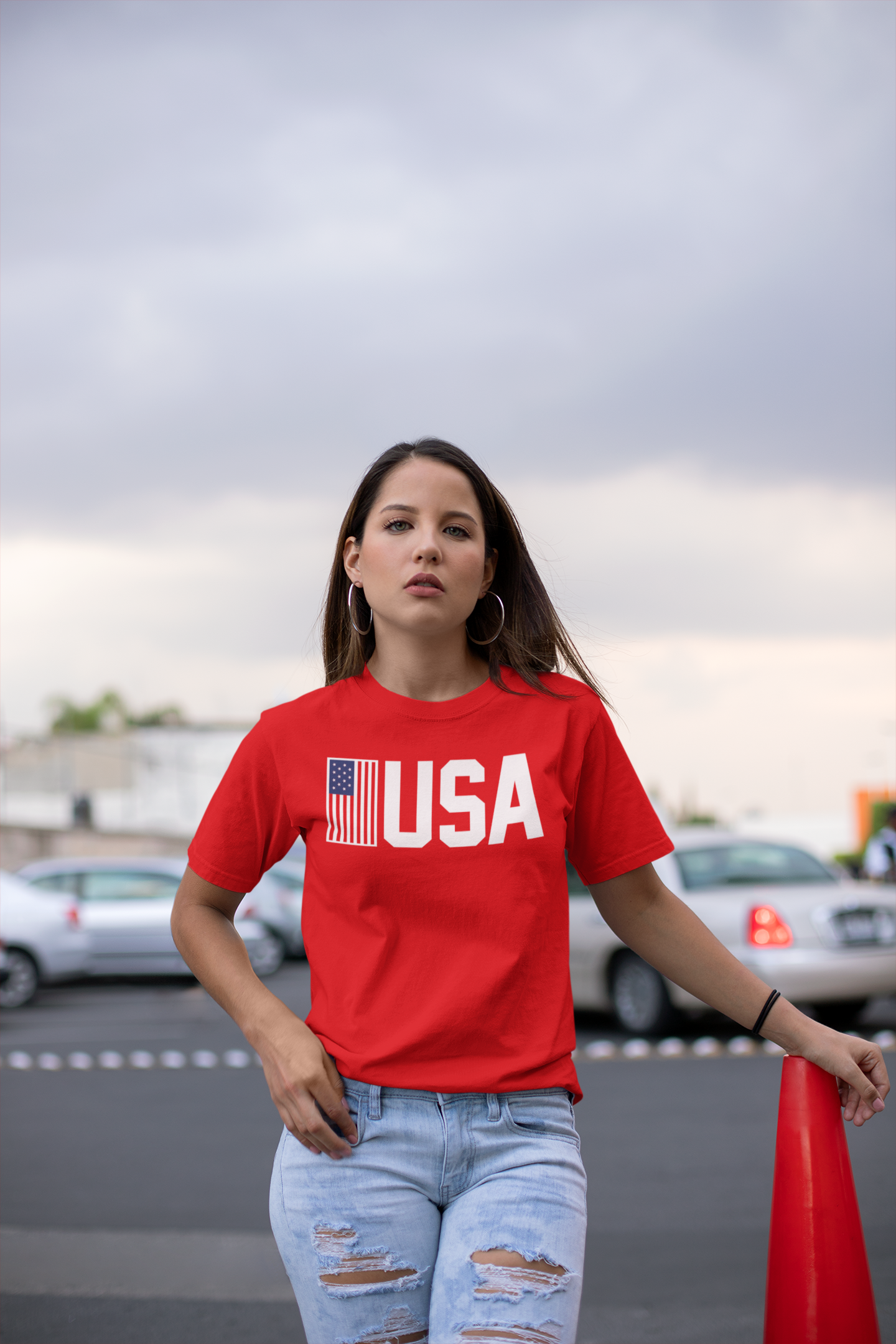 Person wearing a red 'USA' t-shirt with an American flag graphic outdoors.