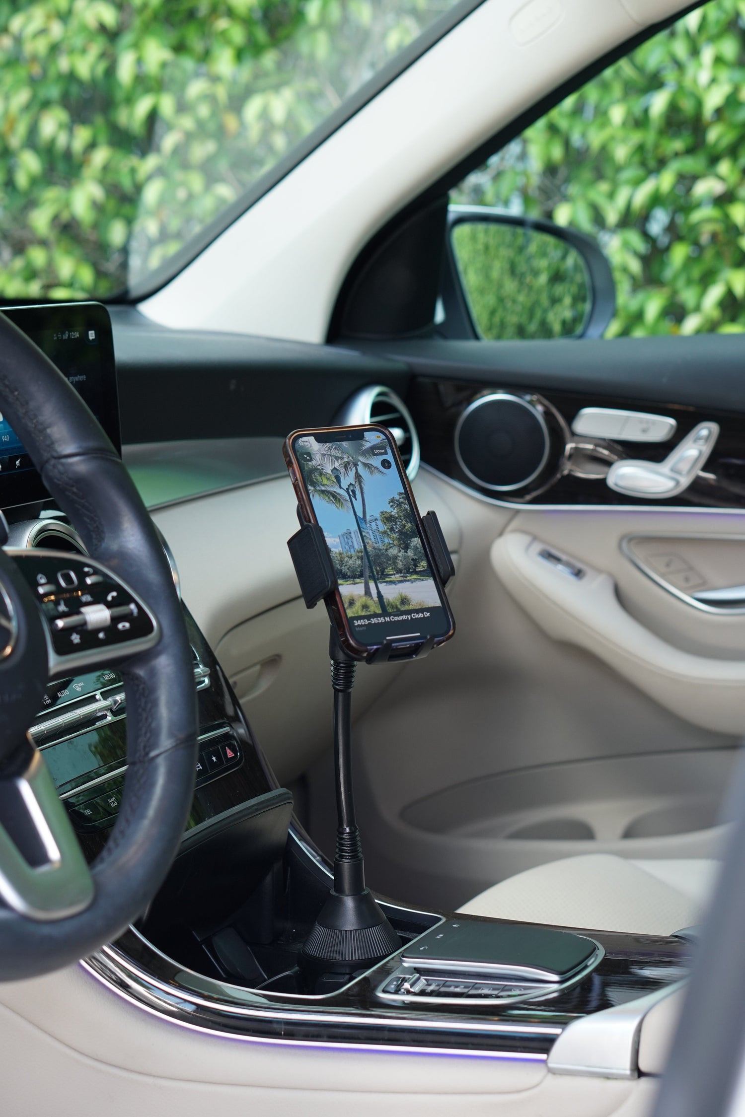 Phone holder in a car dashboard with a phone on it, surrounded by a car interior.