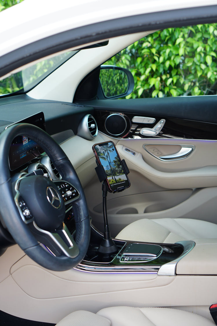 Car interior with a phone mounted on a holder, steering wheel, dashboard, and door panel.