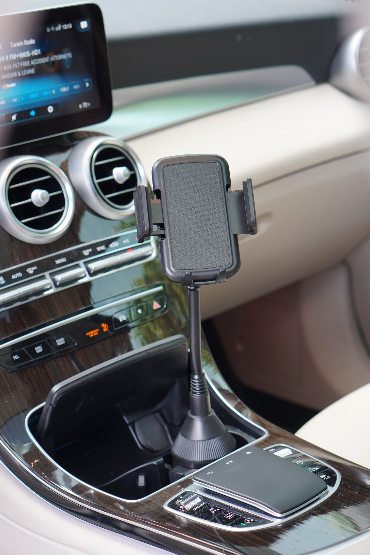 Car phone holder mounted on a car's dashboard with a smartphone on a stand.