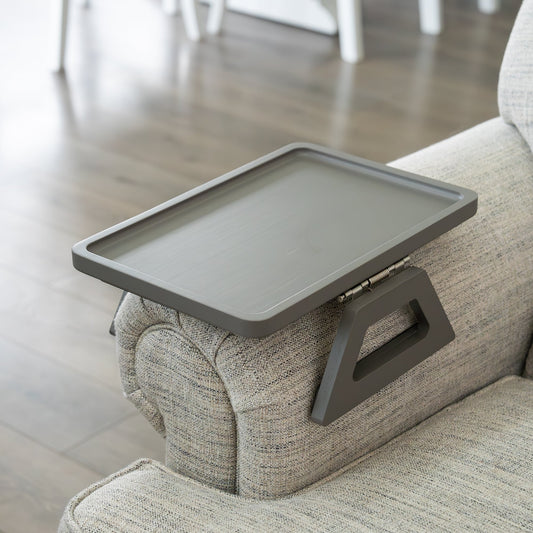 Gray tray attached to a couch armrest in a living room setting