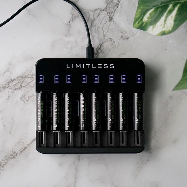 Limitless battery charger on a marble surface with green leaves in the background