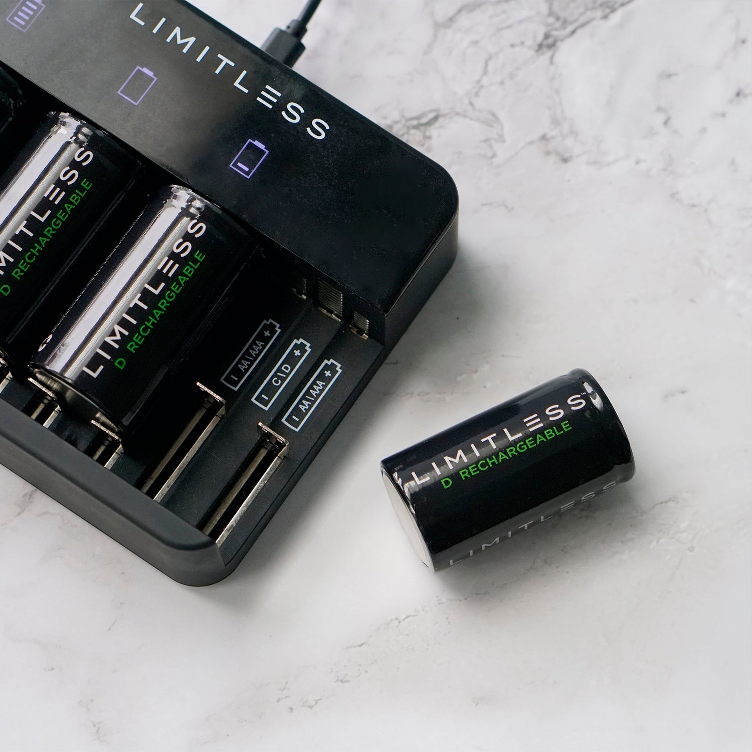 Limitless battery charger and rechargeable batteries on a marble surface