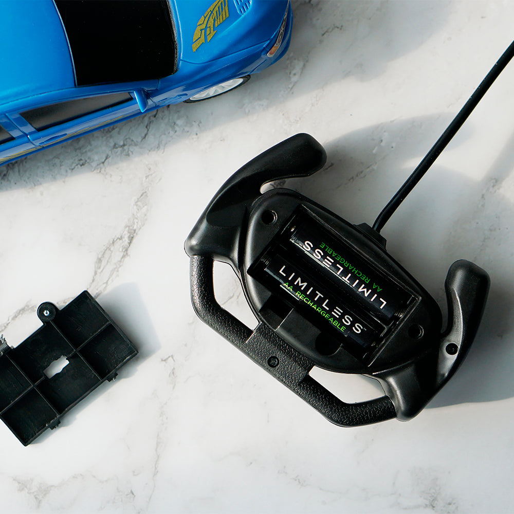 Black remote control with 'Limitless' branding on a marble surface, next to a blue toy car.