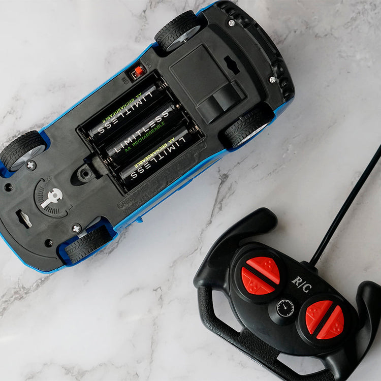 Close-up of a remote control car and its battery compartment on a marble surface