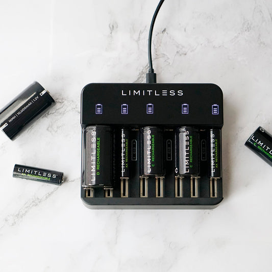 Black battery charger with multiple battery slots and Limitless branding, accompanied byLimitless batteries on a white background.
