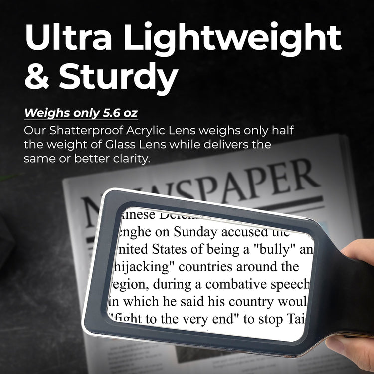 Handheld magnifying glass reading a newspaper with text about weight and durability.