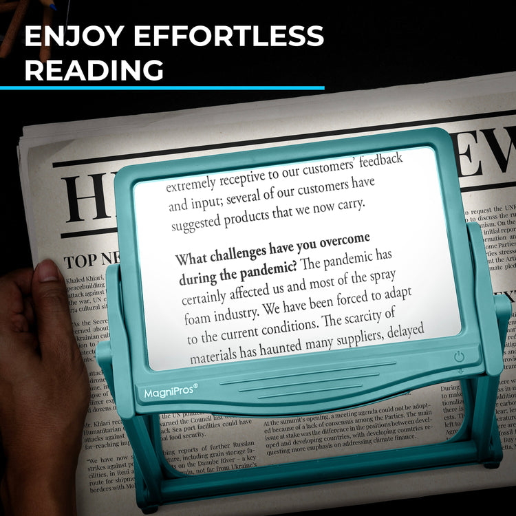 Teal MagniPros reading device held over a newspaper with text displayed.