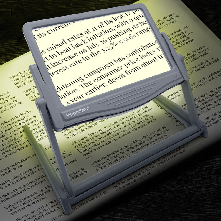 Magnifying glass with light on a book page, highlighting text.