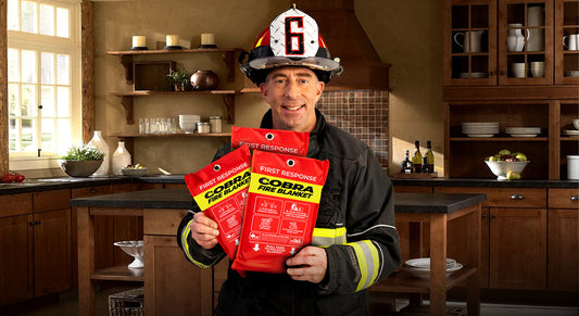 Person in firefighter gear holding COERDA fire blankets in a kitchen.