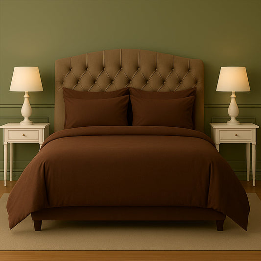 Purple bedding set on a bed with matching pillows in a room with purple walls and wooden nightstands.