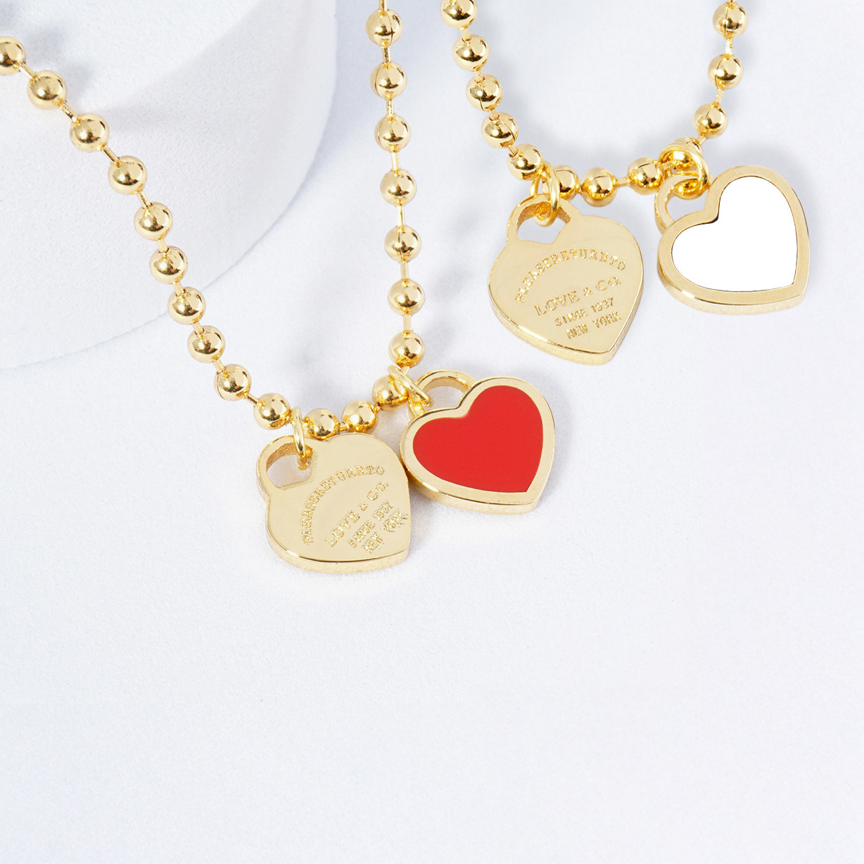 Gold necklace with heart-shaped pendants on a white background