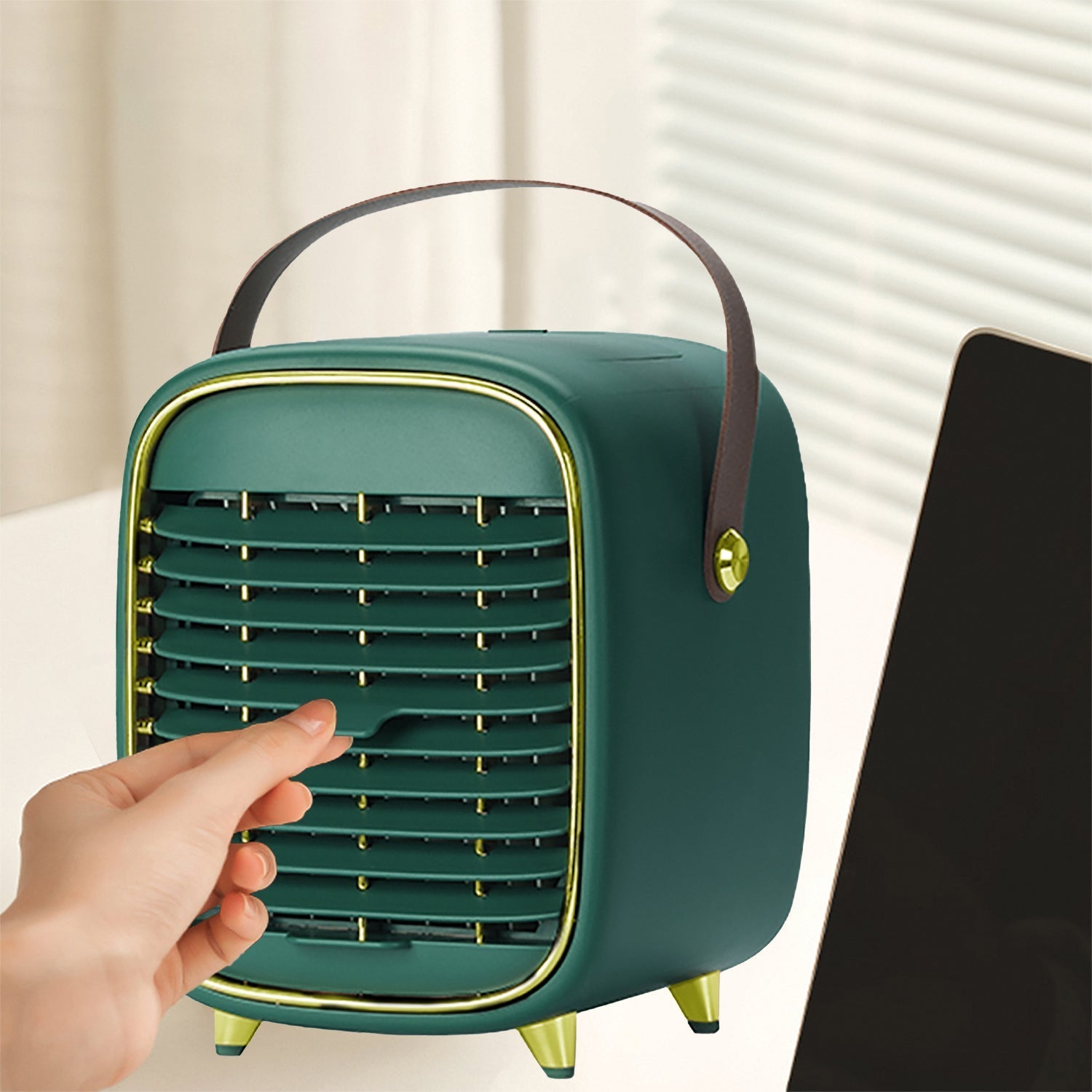 Green portable air conditioner with a hand touching it against a neutral background