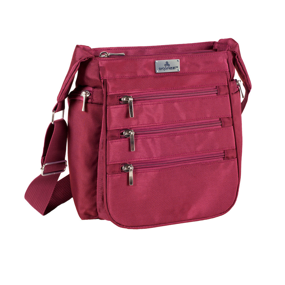 Purple crossbody bag with multiple pockets on a white background