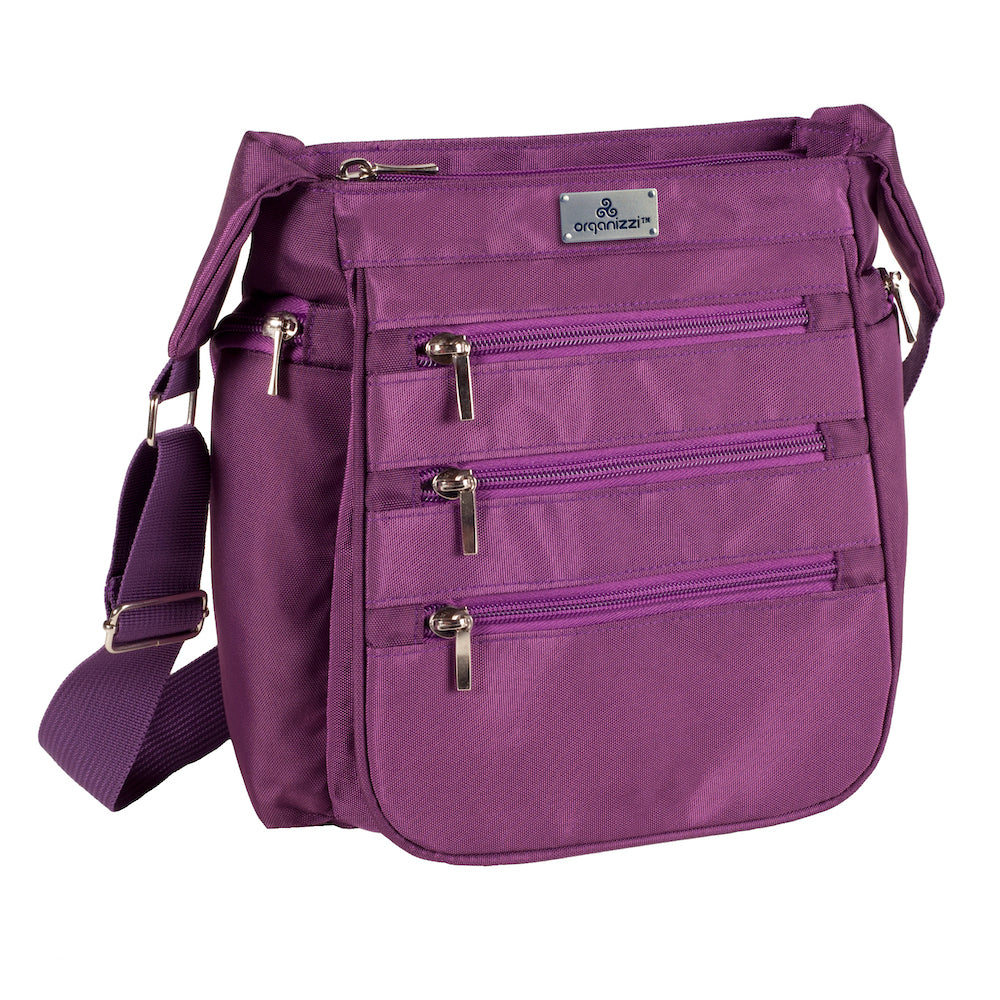 A person walking away from the camera wearing a blue shirt and carrying a black crossbody daybag with shoulder strap.