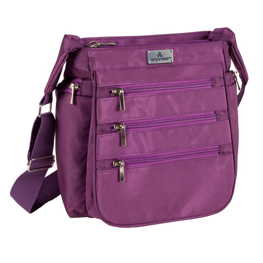 A person walking away from the camera wearing a blue shirt and carrying a black crossbody daybag with shoulder strap.