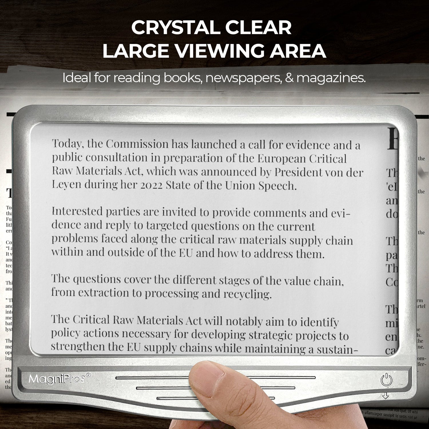E-reader device with a large viewing area displaying text, held over a newspaper.