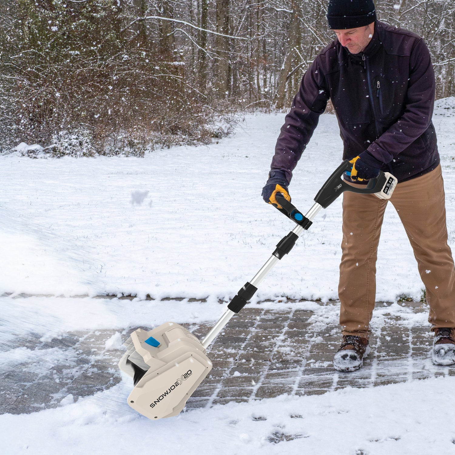 Person using a snow removal tool on a snowy driveway