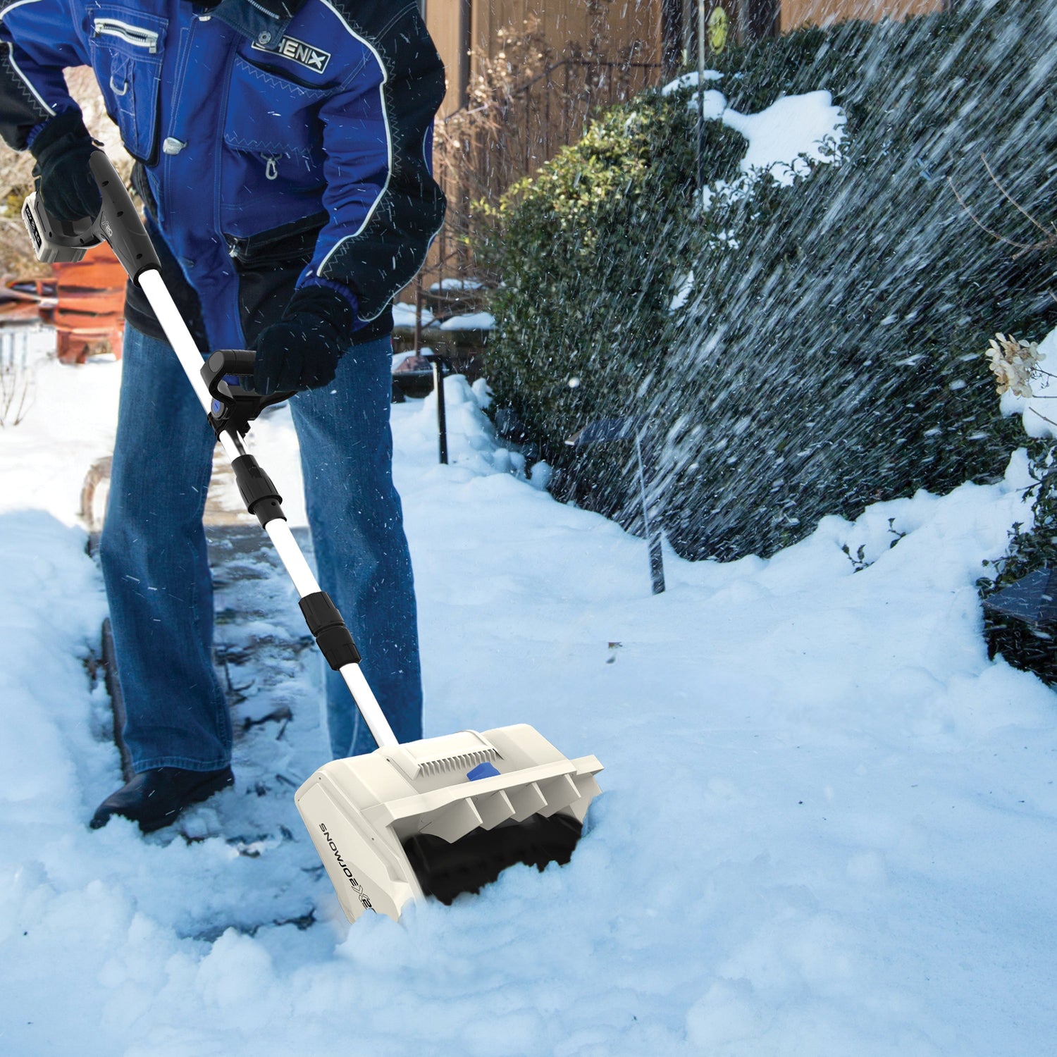Person using a snow broom to clear snow from a path