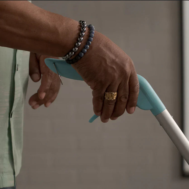 Hand holding a blue handle with a blurred background