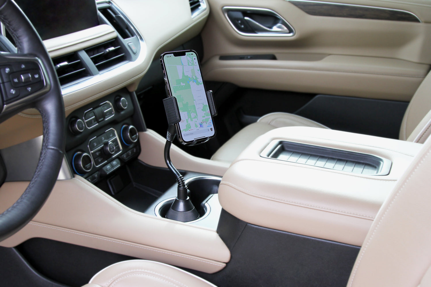 Car interior with a phone holder displaying a phone on a beige dashboard.